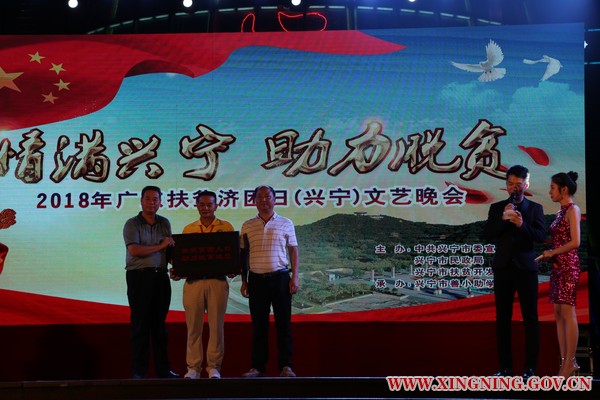 市民政局长何群标、扶贫局长刘尚方向兴宁善小助学协会会长刘选仁先生授予《关爱贫困人口 助力脱贫攻坚》的牌匾.jpg